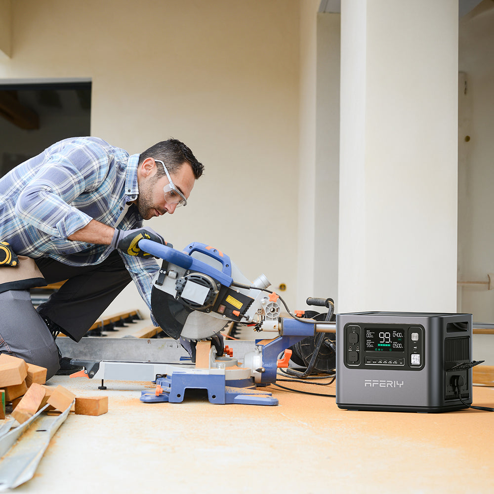 A man is using a AFERIY P110 1200W 1248Wh portable power station to power a cutting machine.